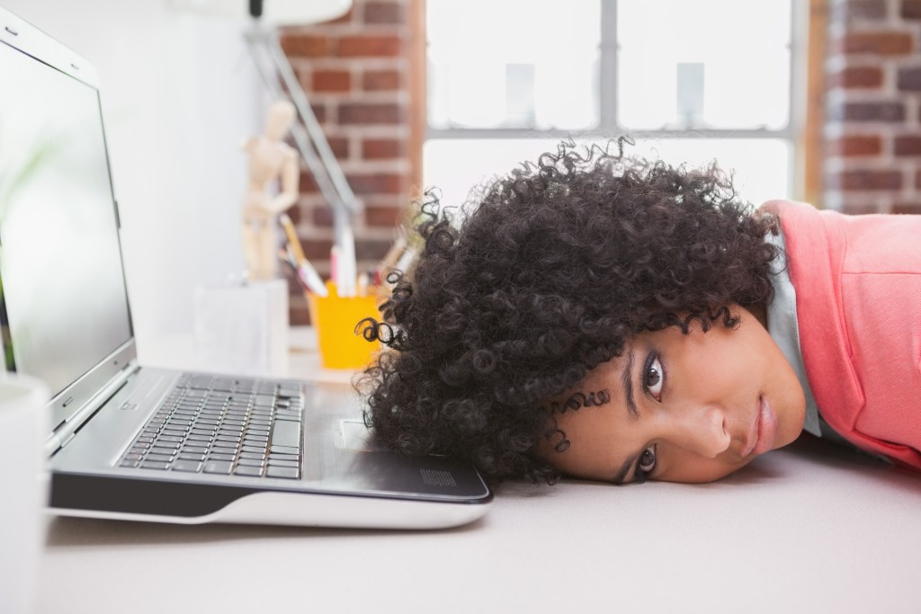 Casual businesswoman resting head on desk